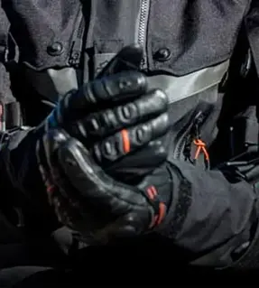 Motero ajustándose guantes Harley-Davidson.
