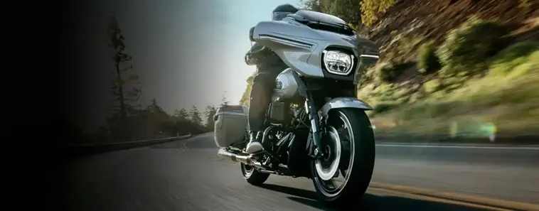 Motero en moto Harley-Davidson a velocidad en carretera.